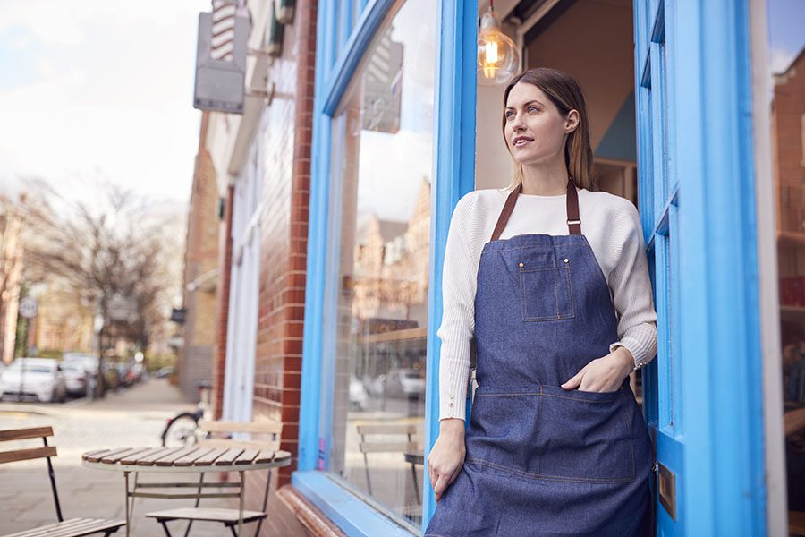 Commercial Insurance - Portrait of a Young Female Small Business Owner Standing Outside Her Cafe on the Main Street